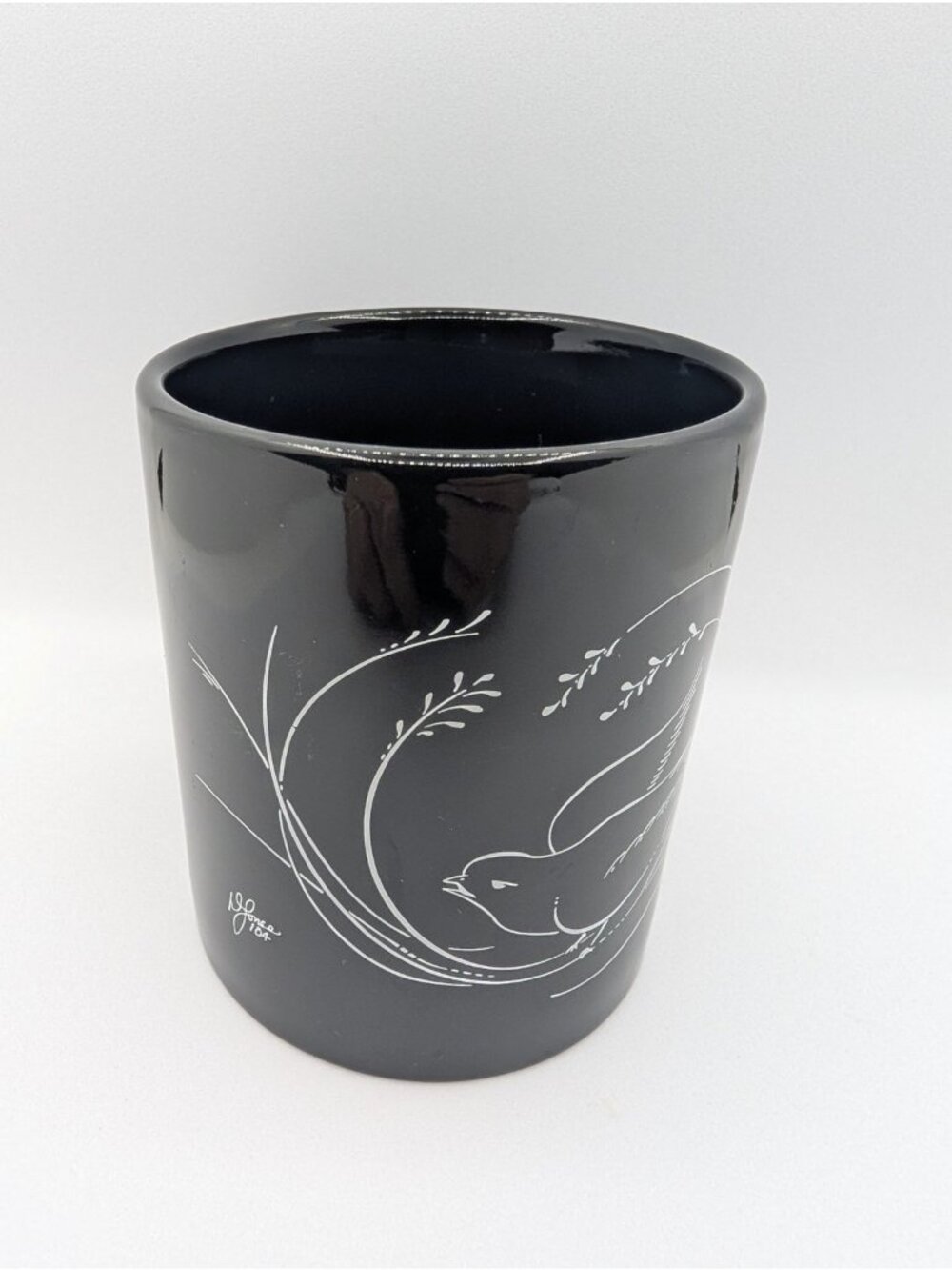 M Ware Black mug with white ribbon lines bird textured signed L? Jones 104